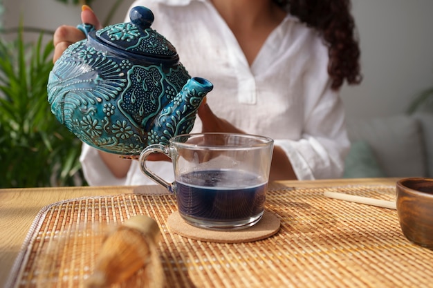 Free Photo front view woman enjoying blue matcha at home