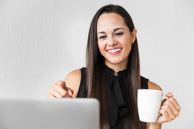 Front view woman enjoying her cup of coffee at the office