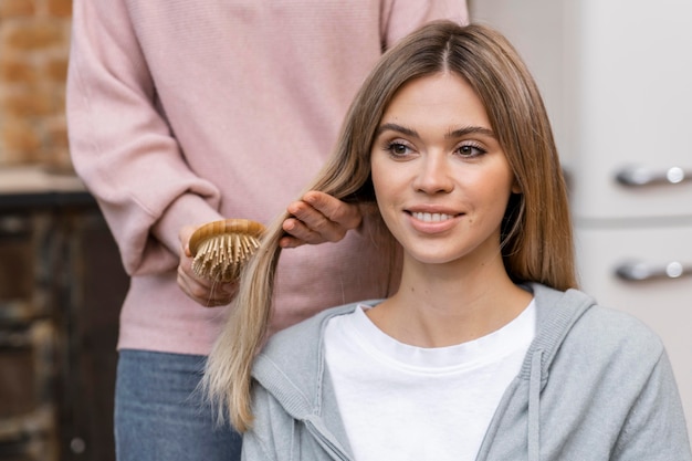 Free photo front view of woman getting her hair brushed at the salon