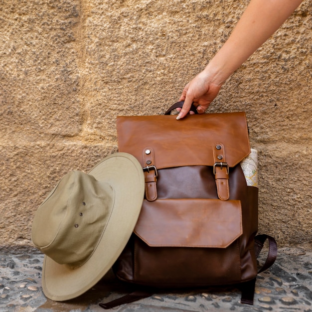 Free Photo front view woman grabbing backpack from the ground