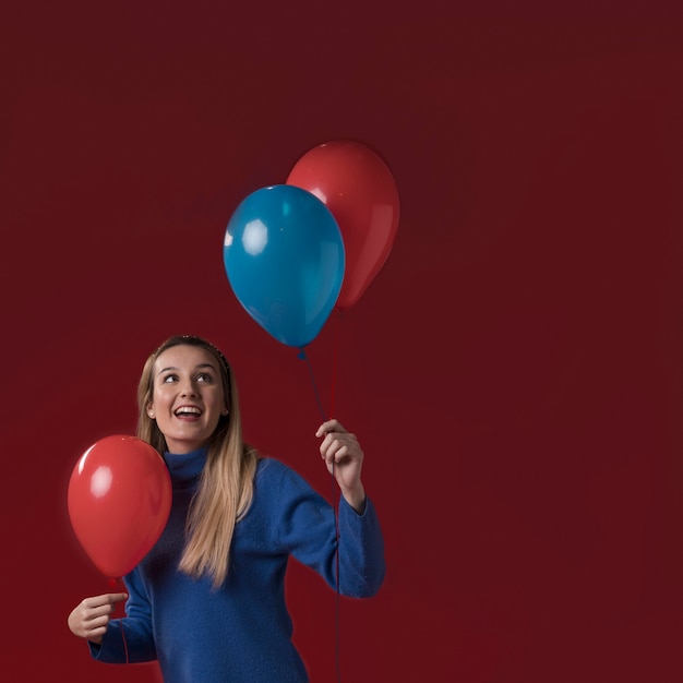 Free photo front view woman holding balloons