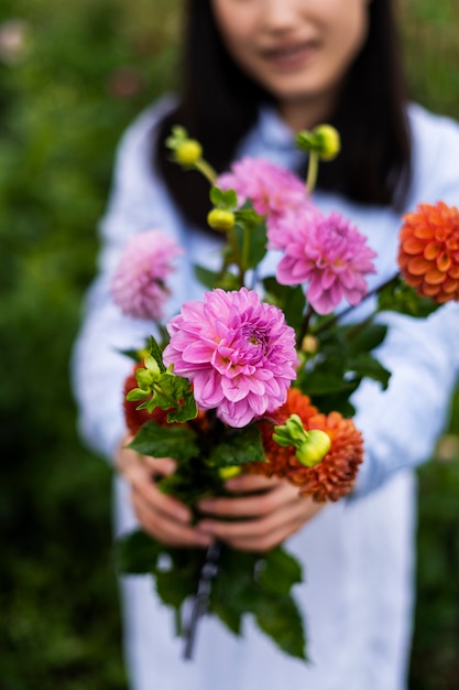 Free photo front view woman holding beautiful flowers