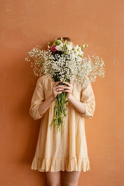 Front view of woman holding bouquet of gorgeous spring flowers