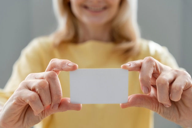 Free Photo front view woman holding business card