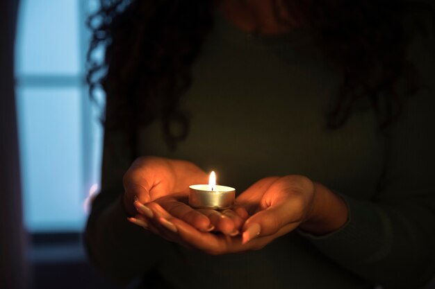 Front view woman holding candle at home