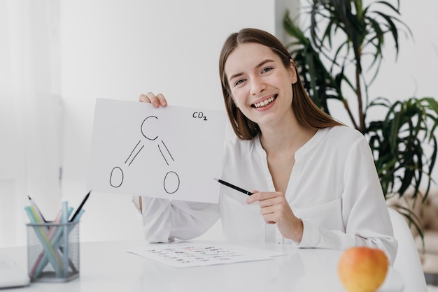 Front view woman holding a chemistry drawing