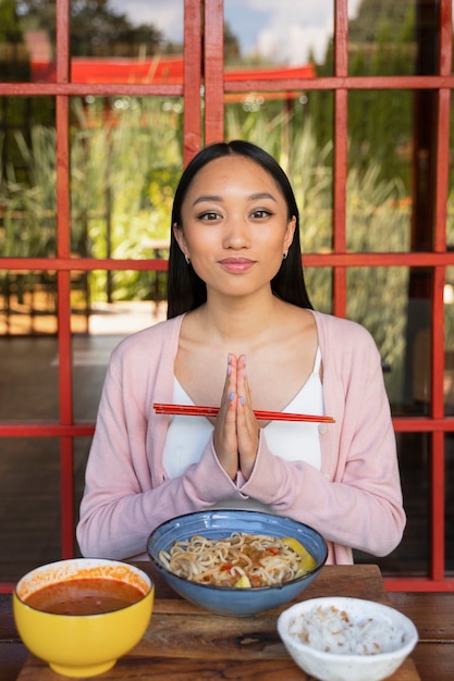 Free photo front view woman holding chopsticks