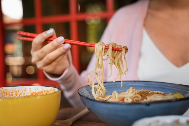 Free Photo front view woman holding chopsticks