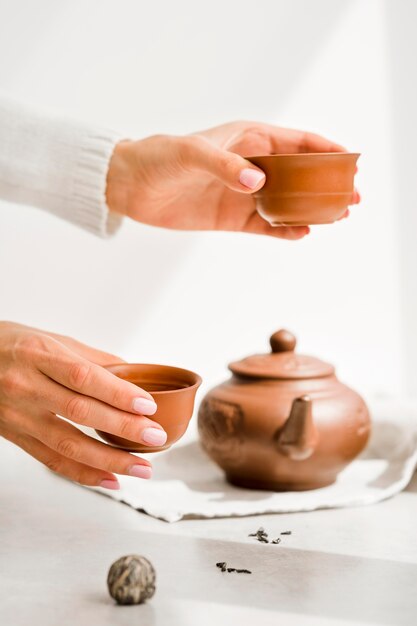 Front view woman holding clay teacups