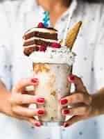 Free photo front view of woman holding delicious milkshake