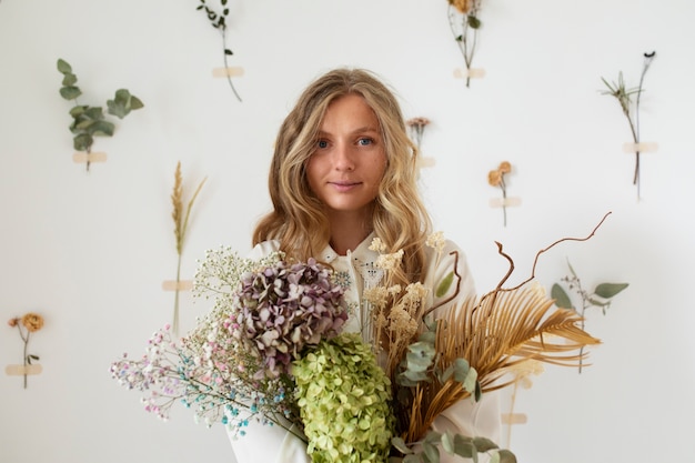 Free photo front view woman holding dried flowers