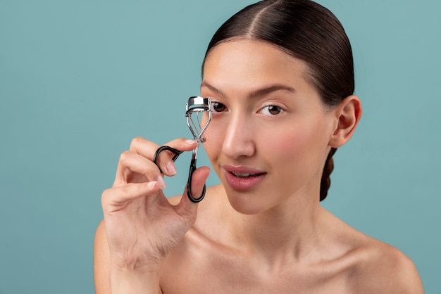 Front view woman holding eyelash curler