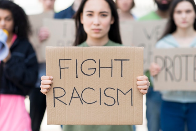 Free photo front view woman holding fight racism quote