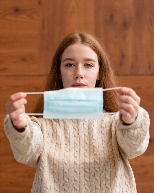 Front view of woman holding medical mask