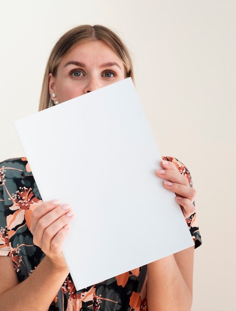 Front view woman holding a mock-up magazine