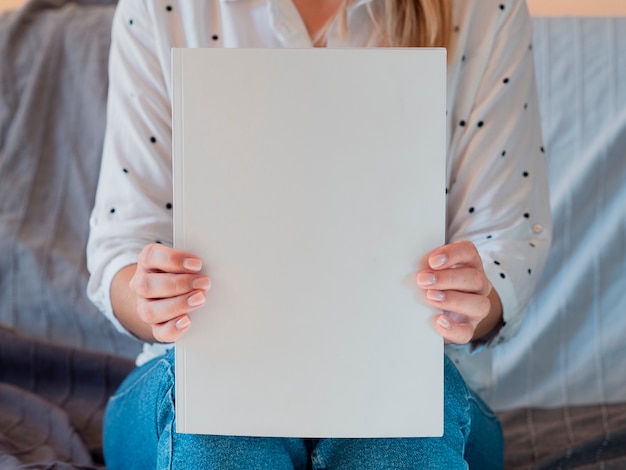 Front view woman holding a mock-up magazine