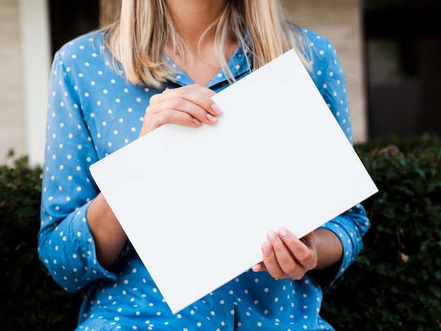 Front view woman holding a mock-up magazine