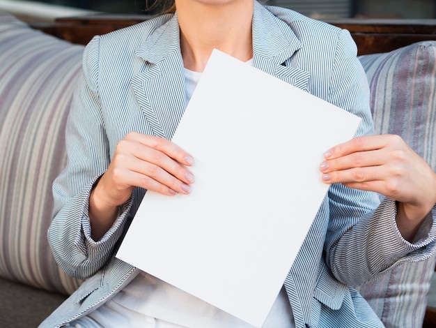 Free photo front view woman holding a mock-up magazine