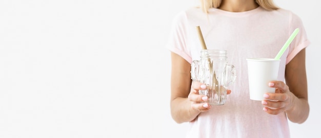 Front view woman holding plastic cups with copy space