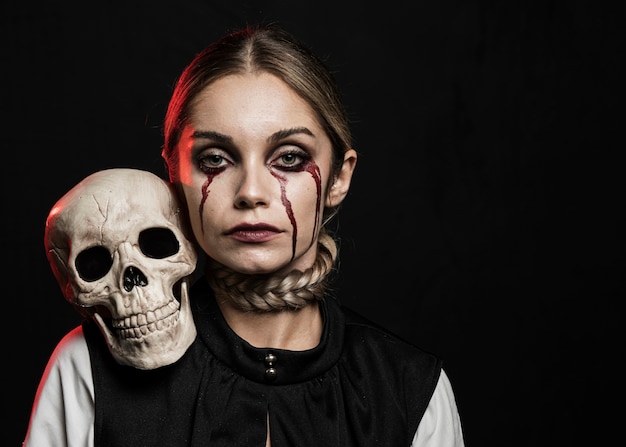 Free photo front view of woman holding skull on shoulder