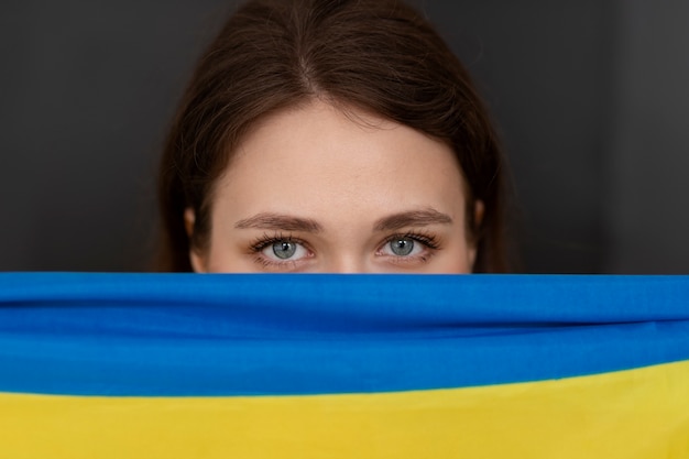 Free Photo front view woman holding ukrainian flag