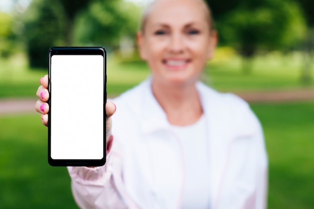 Front view woman holding up a smartphone