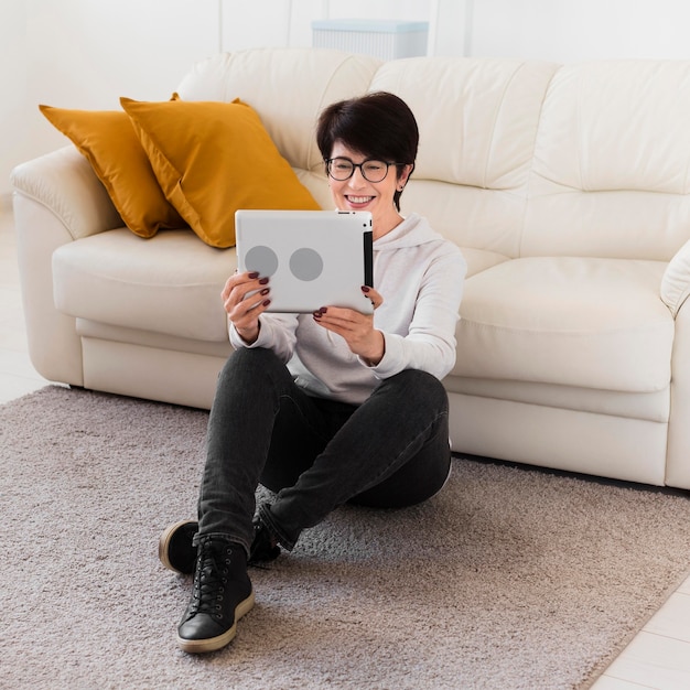 Front view of woman at home with tablet