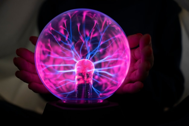 Front view woman interacting with a plasma ball