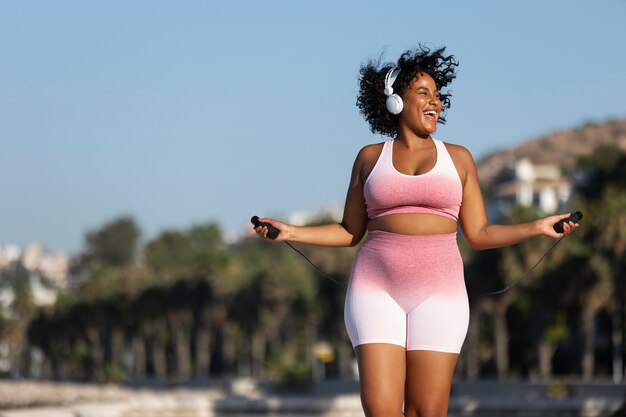 Front view woman jumping rope outdoors