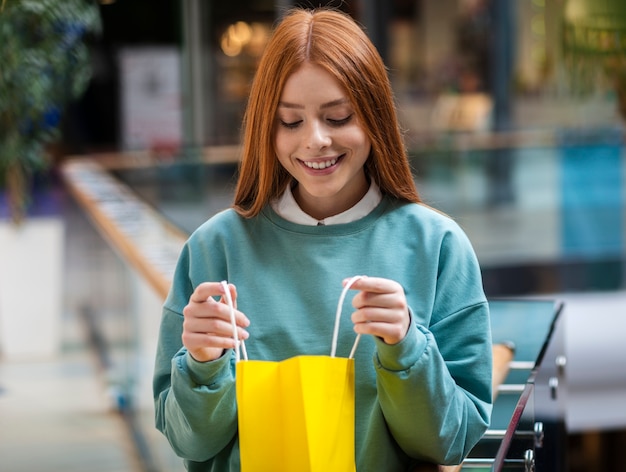 Free photo front view woman looking in a shopping bag