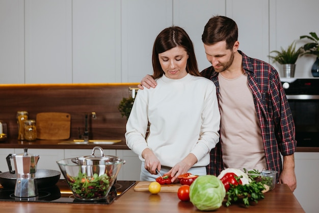 Free photo front view of woman and man preparing food in the kitchen