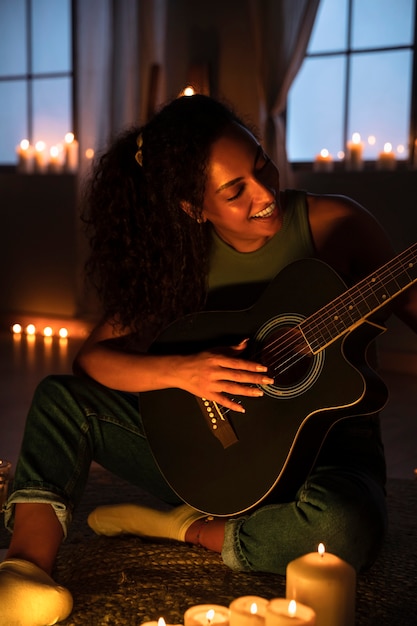 Free photo front view woman playing the guitar