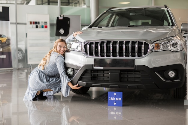 Free photo front view woman posing next to a car