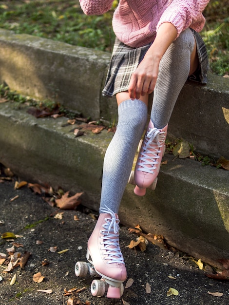 Free photo front view of woman posing on stairs with socks and roller skates