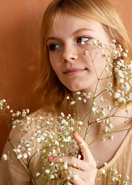 Front view of woman posing with beautiful flowers