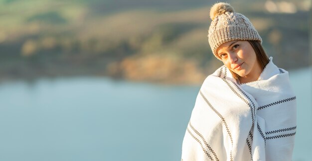 Front view of woman posing with blanket on while on a road trip