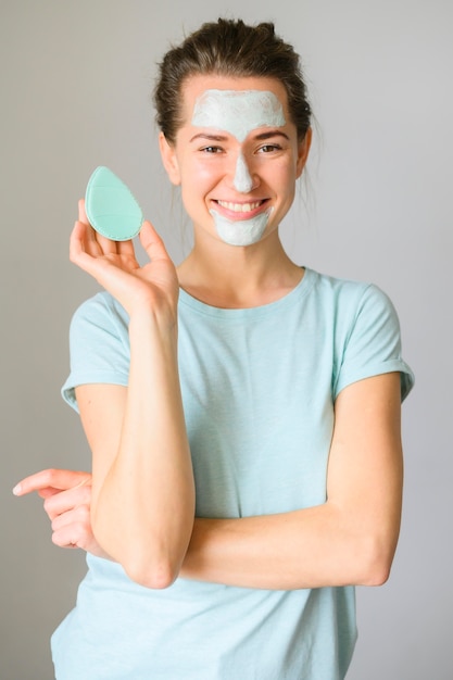 Front view of woman posing with face cream on