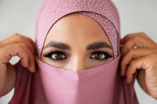 Front view woman posing with pink hijab