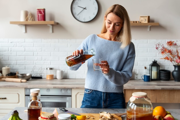 Front view woman pouring kombucha