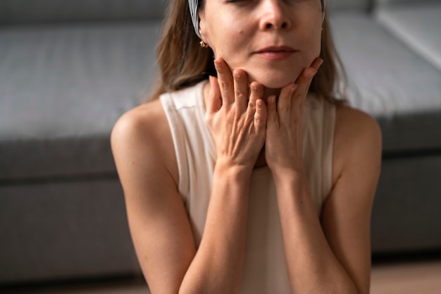 Free photo front view woman practicing facial yoga