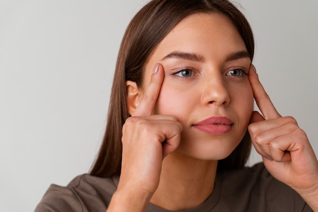 Front view woman practicing facial yoga