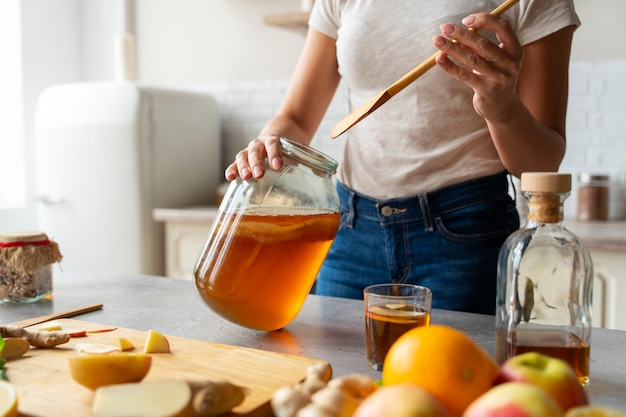 Free photo front view woman preparing kombucha