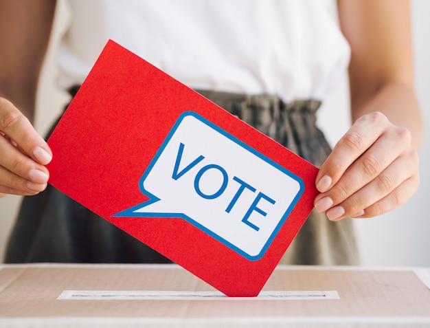 Front view woman putting a voting message in a box