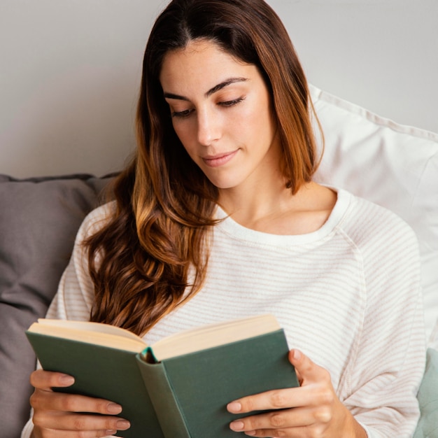 Front view of woman reading a book at home