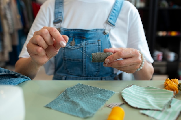 Free photo front view woman repairing fashion goods