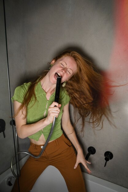 Front view woman singing in bathtub