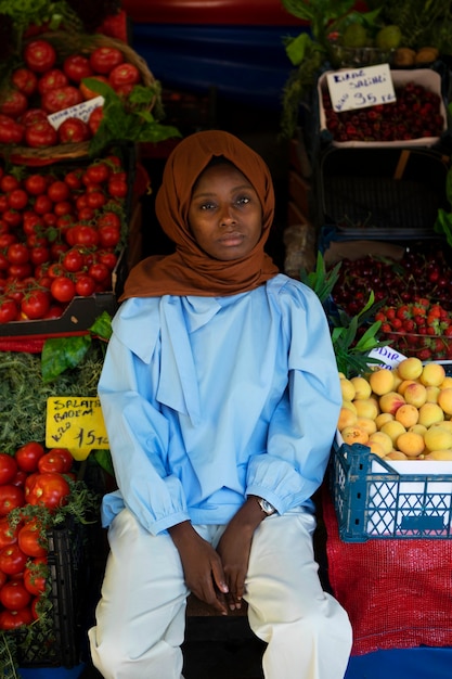 Free photo front view woman sitting near fruits