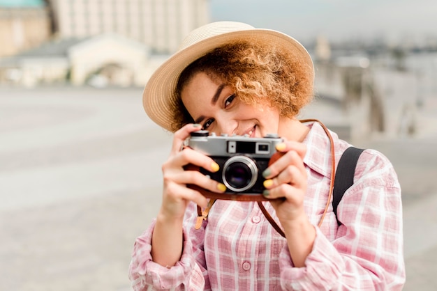 Free photo front view woman taking a photo with a camera while traveling