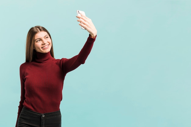 Free Photo front view woman taking a selfie in studio