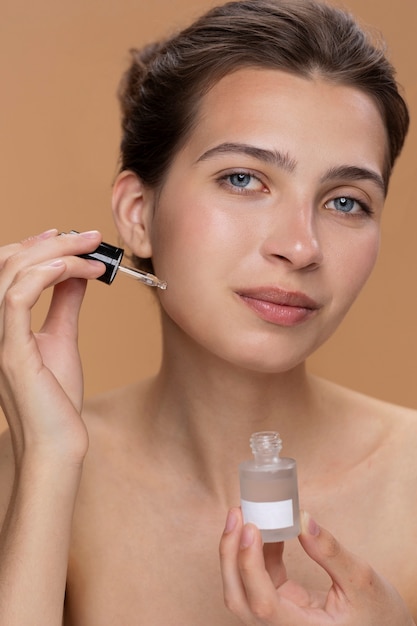 Free photo front view woman using face serum